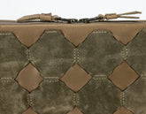 Close-up of a brown leather pouch with geometric pattern and brand logo.