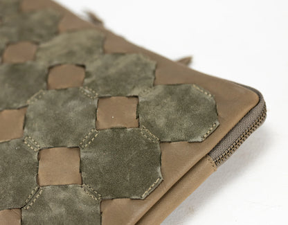 Close-up of a brown leather pouch with hexagonal pattern on a white background
