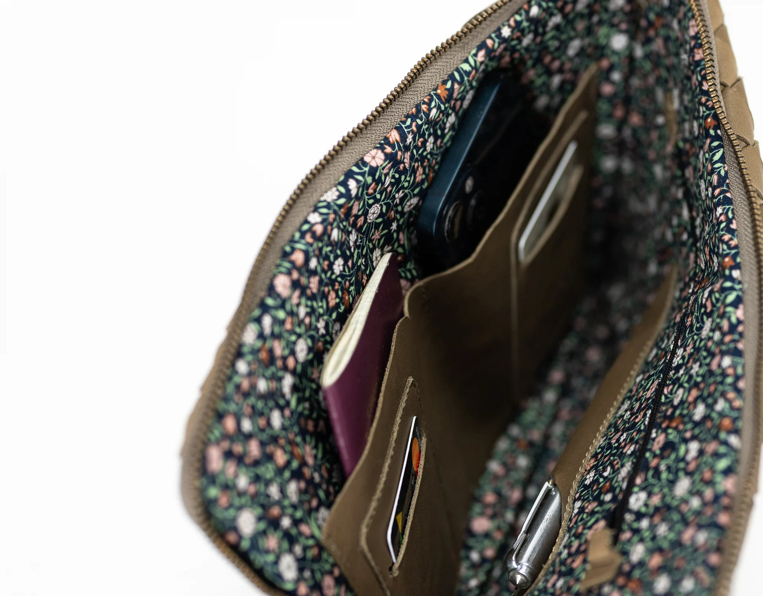 Floral-patterned pouch with a phone and passport inside on a white background