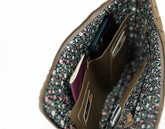 Floral-patterned pouch with a phone and passport inside on a white background