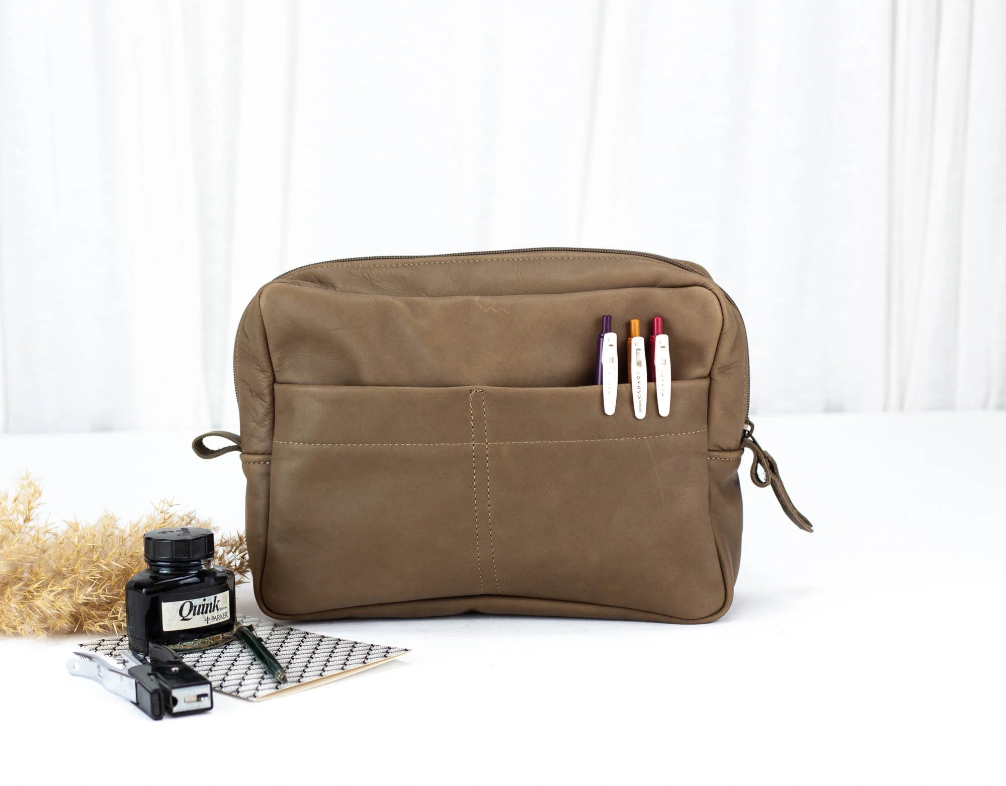 Khaki Brown toiletry bag with markers on a white background