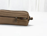 Brown leather pouch with a zipper on a white background