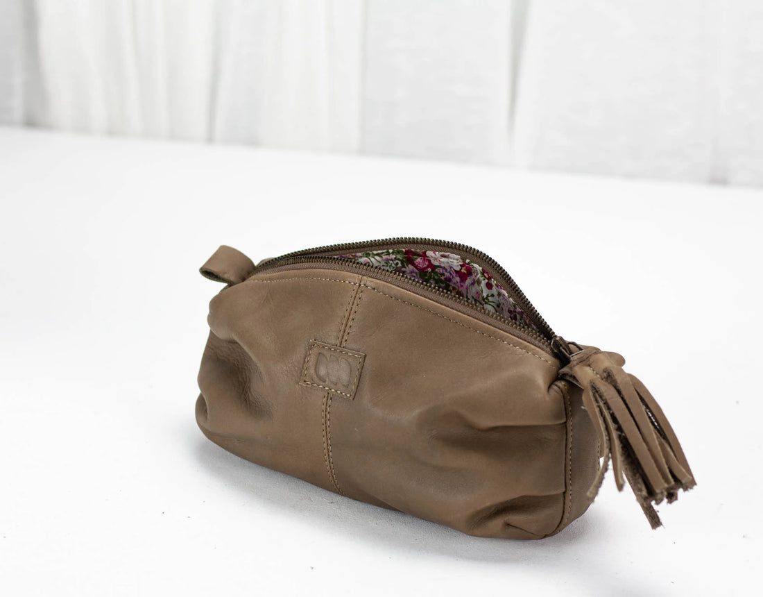 Brown leather pouch with floral interior on a white background