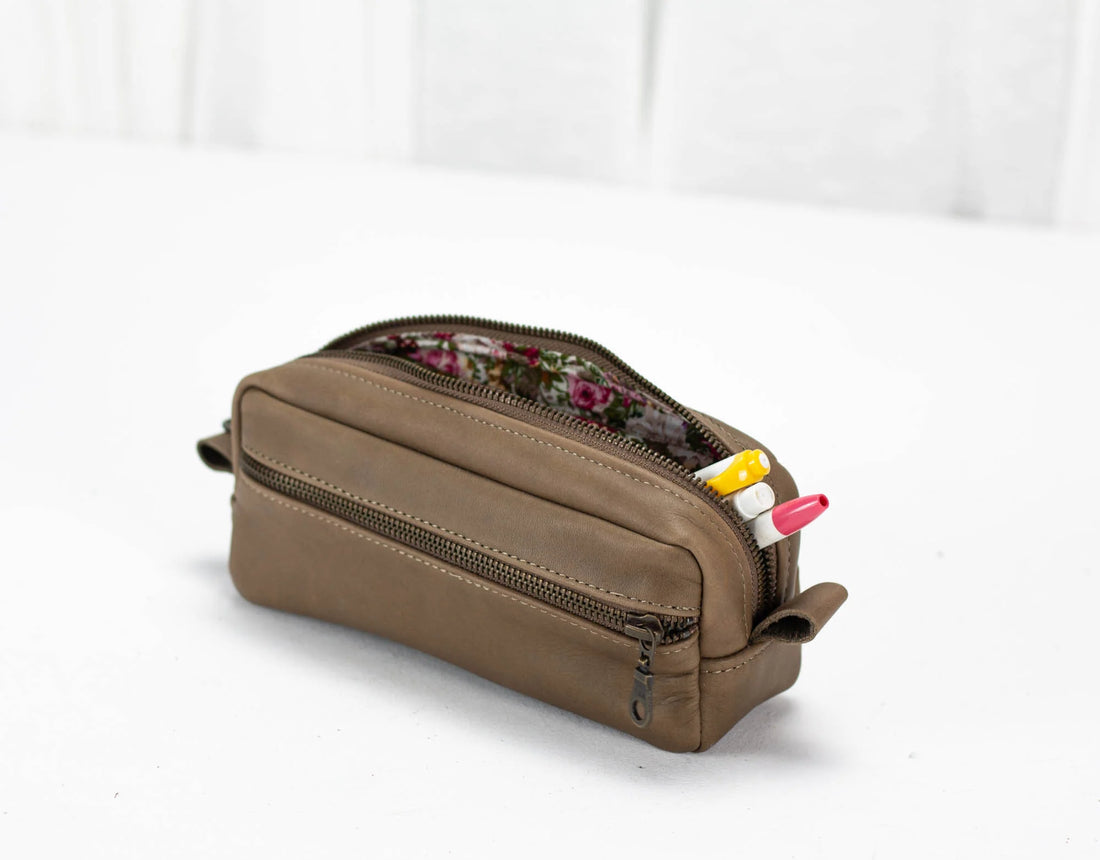 Brown leather pencil case with floral interior on a white background