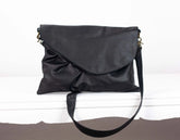 Black leather handbag on a white surface
