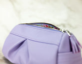 Purple pouch with floral zipper pull on a light background