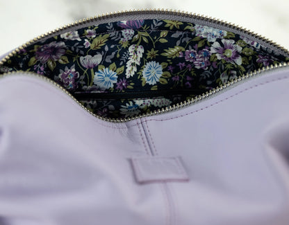 Close-up of a purple garment with floral lining inside a zipper pocket.