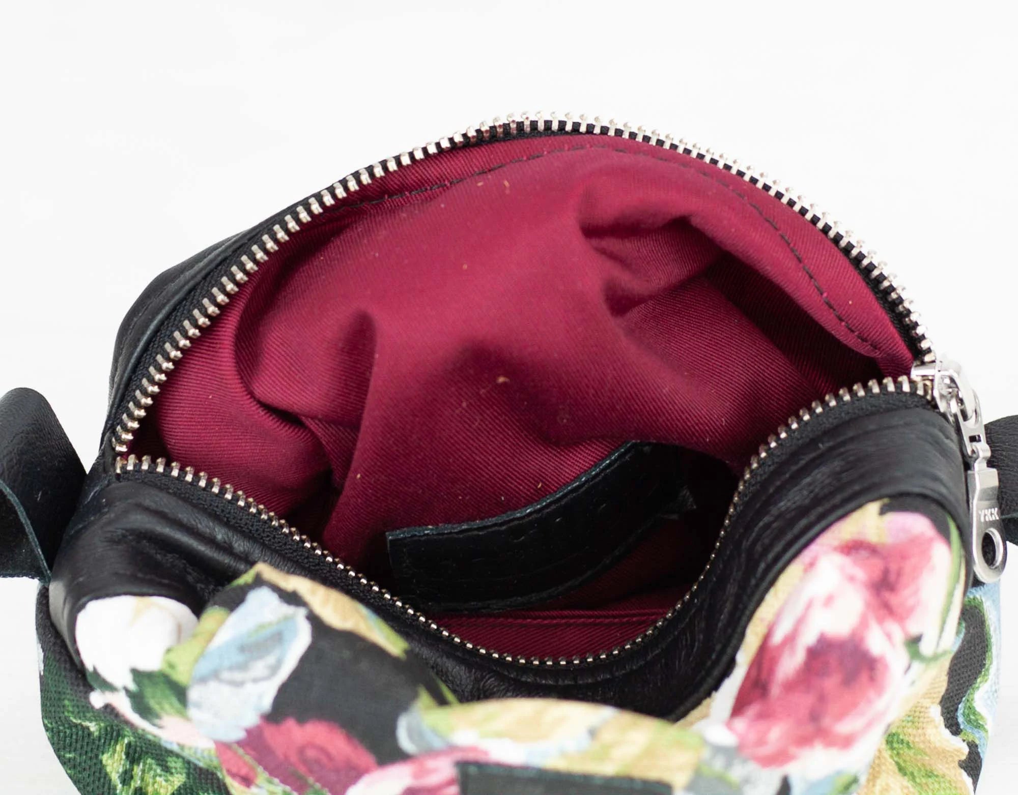 Floral-patterned bag with open zipper showing red interior