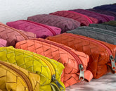 Colorful woven leather pouches arranged on a flat surface.