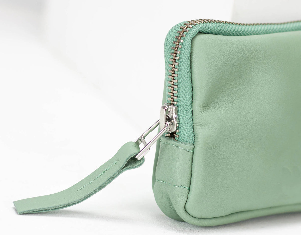 Light green clutch bag with a strap on a white background#color_mint-green