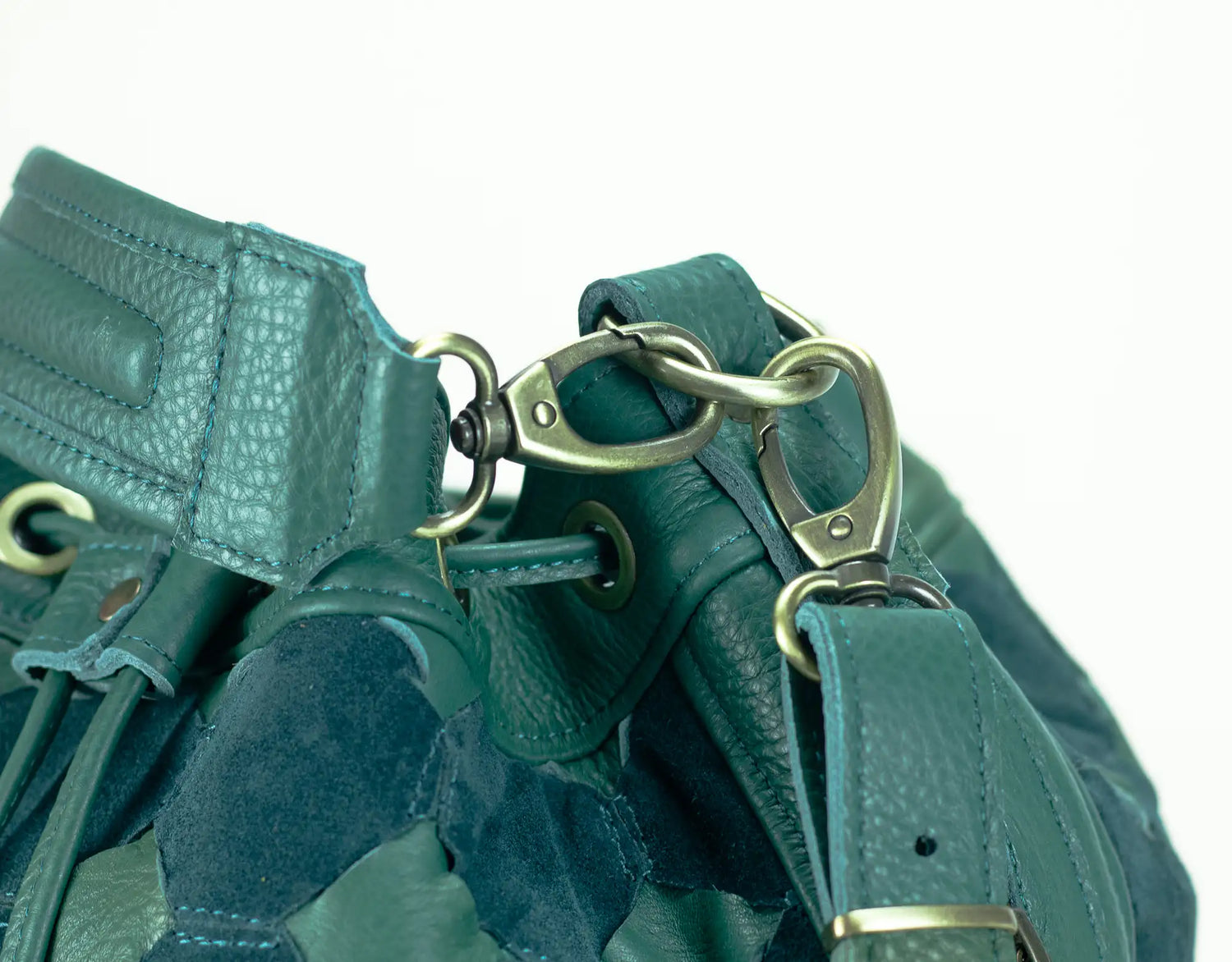 Close-up of a green leather bag with gold hardware on a white background
