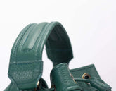 Green leather handbag with textured surface on a white background