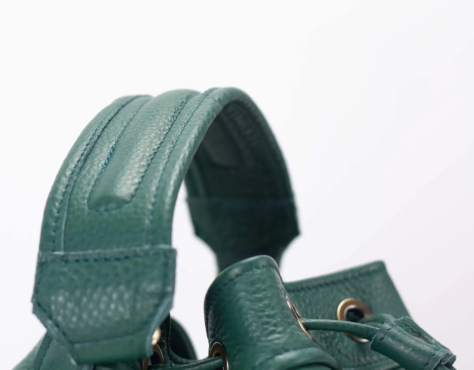 Green leather handbag with textured surface on a white background