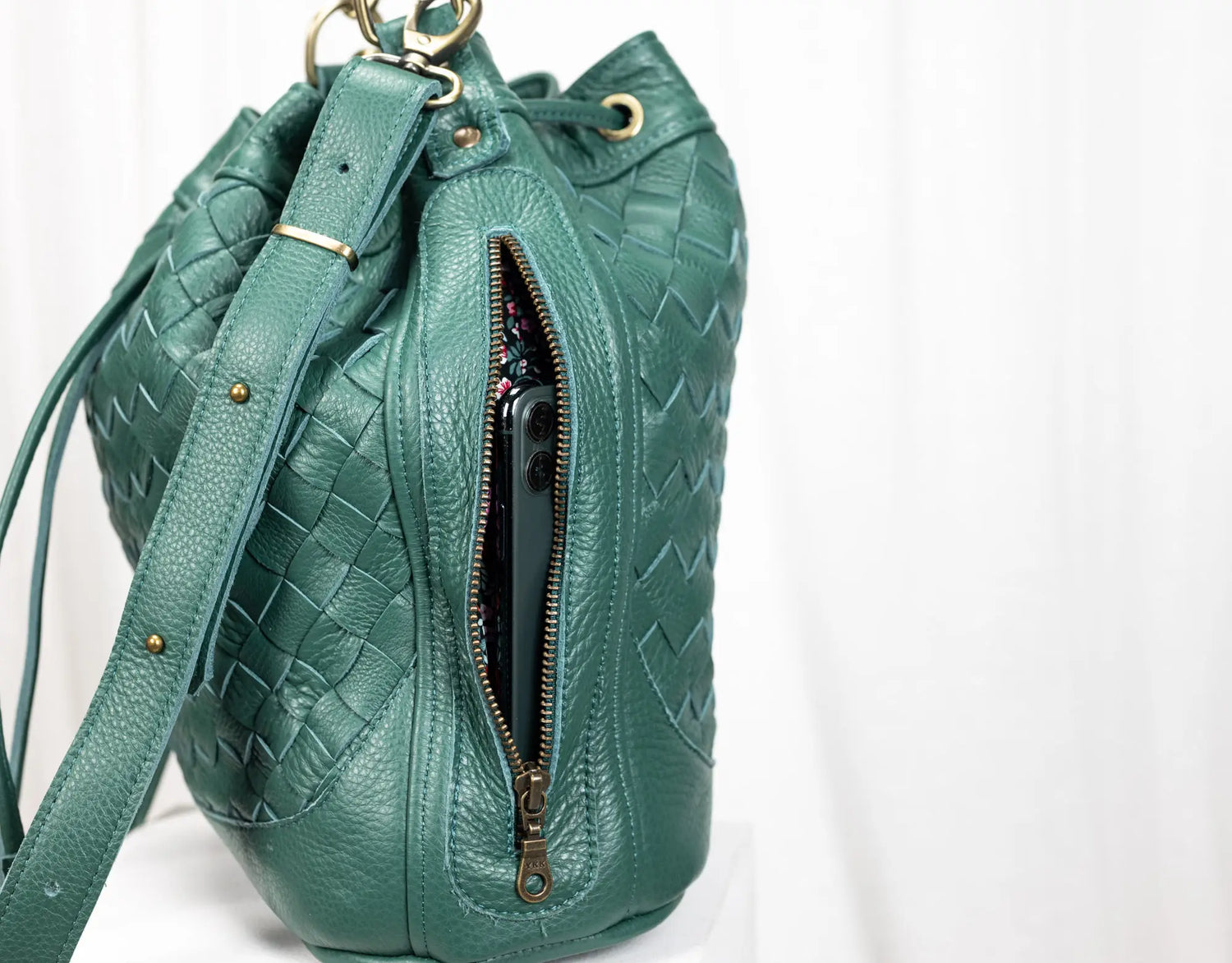 Green textured handbag with a zipper on a white background