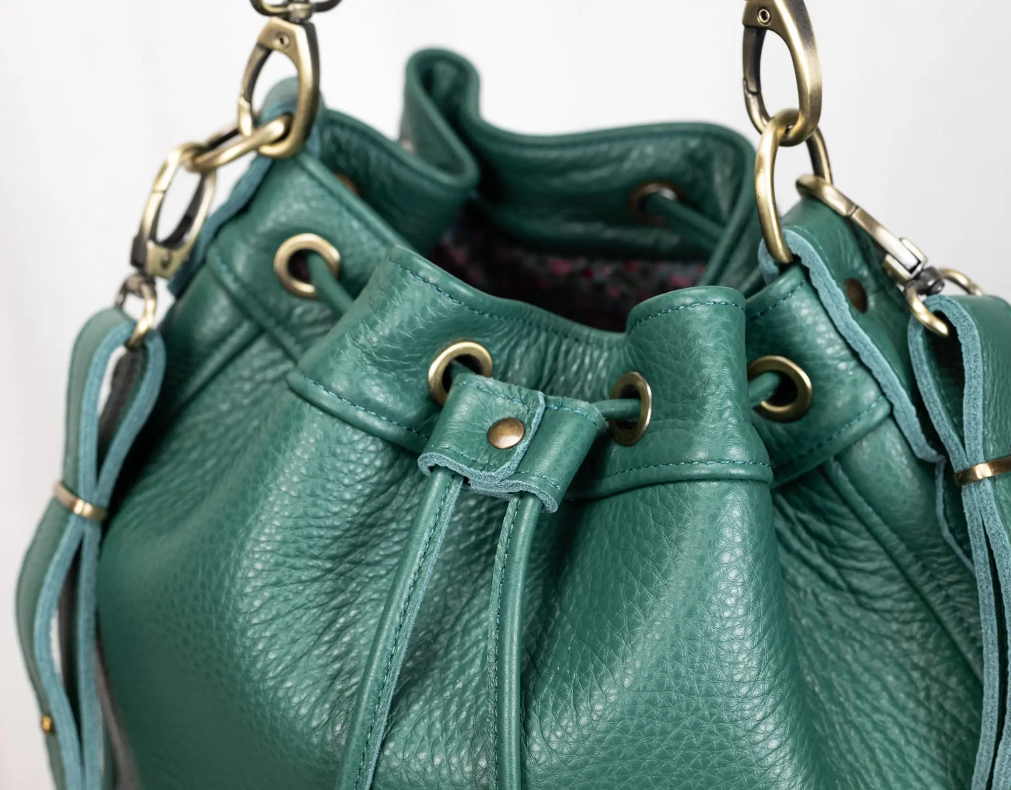 Green leather handbag with gold hardware on a white background