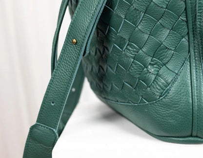 Green leather handbag with woven pattern on a white background