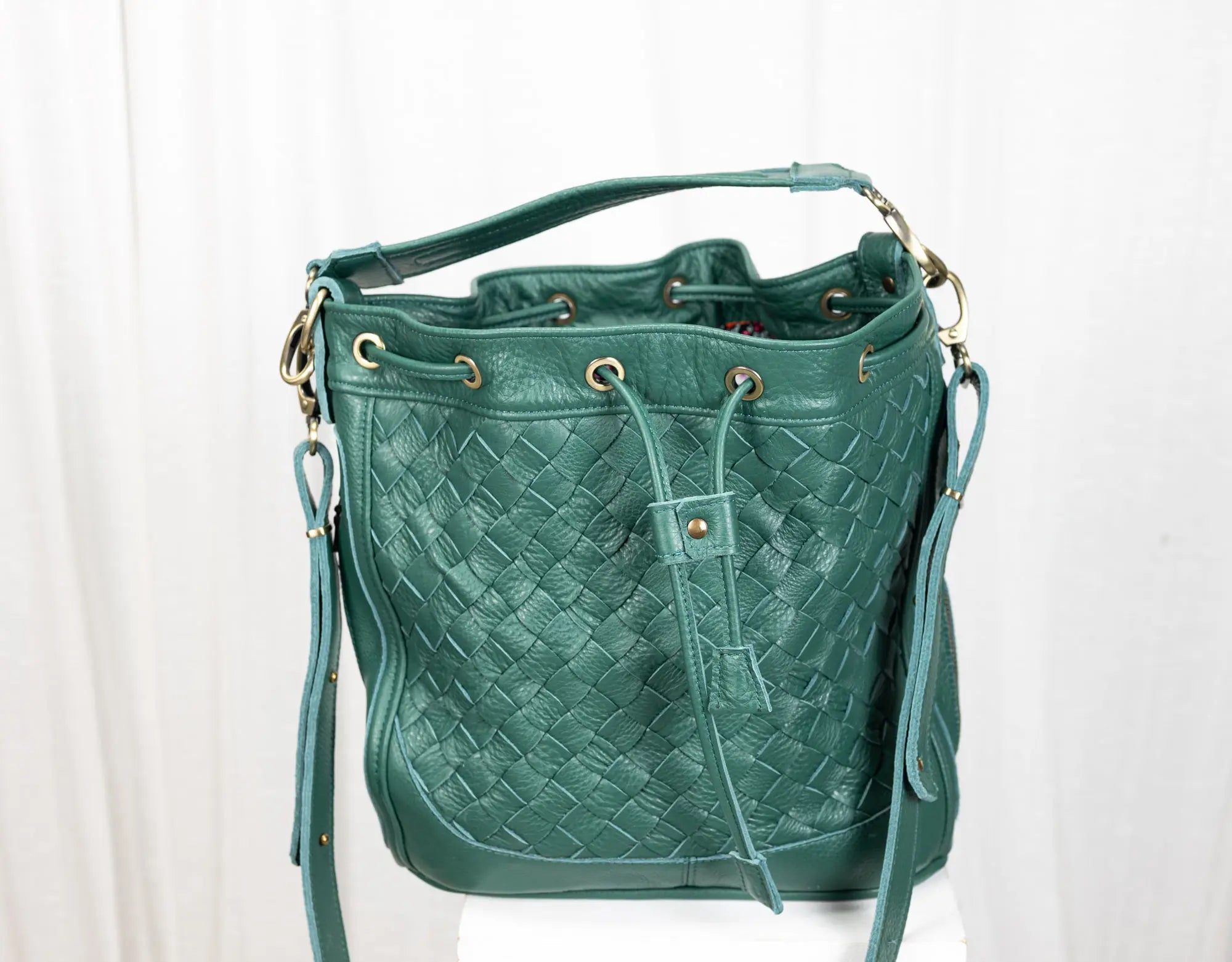 Green woven handbag on a white background