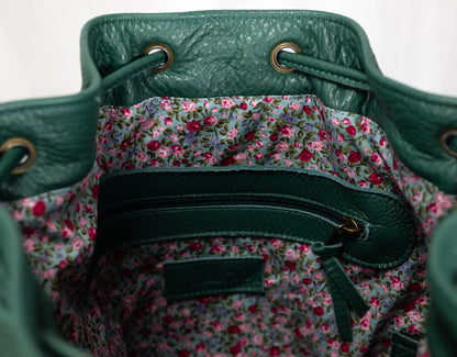 Green leather bag with floral lining on a white background