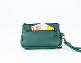 Green leather handbag with a strap on a white background
