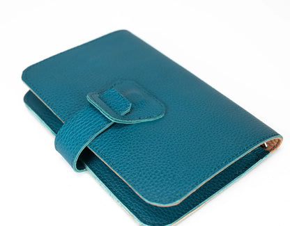 Teal textured wallet with a buckle on a white background