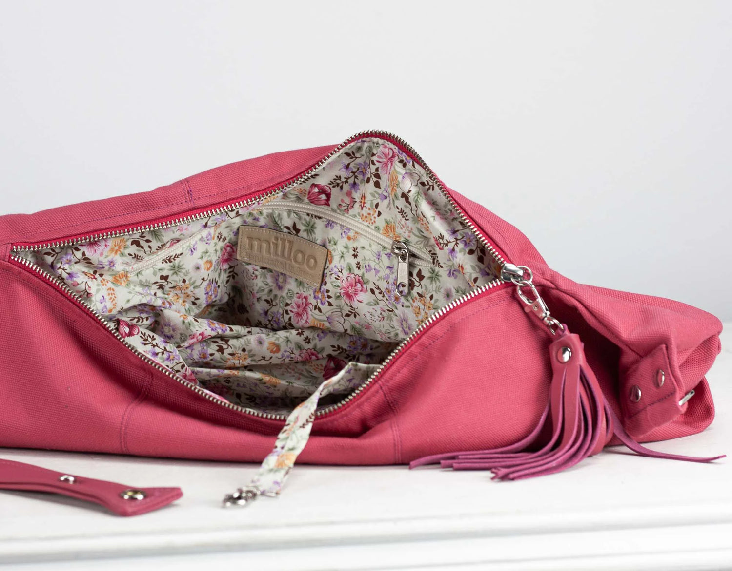 Pink handbag with floral interior on a white background