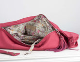 Pink handbag with floral interior on a white background