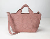 Pink quilted handbag on a white background