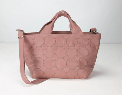 Pink quilted handbag on a white background