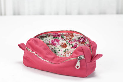 Pink cosmetic bag with floral interior on a white background