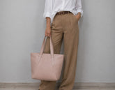 a woman holding a pink tote bag 