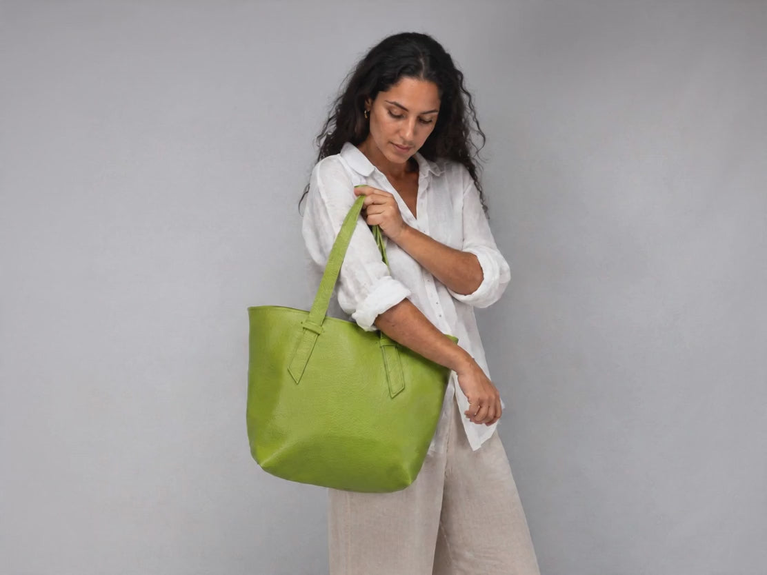 A woman carrying a lime green leather tote bag 