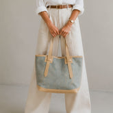 A woman carrying a denim tote bag 