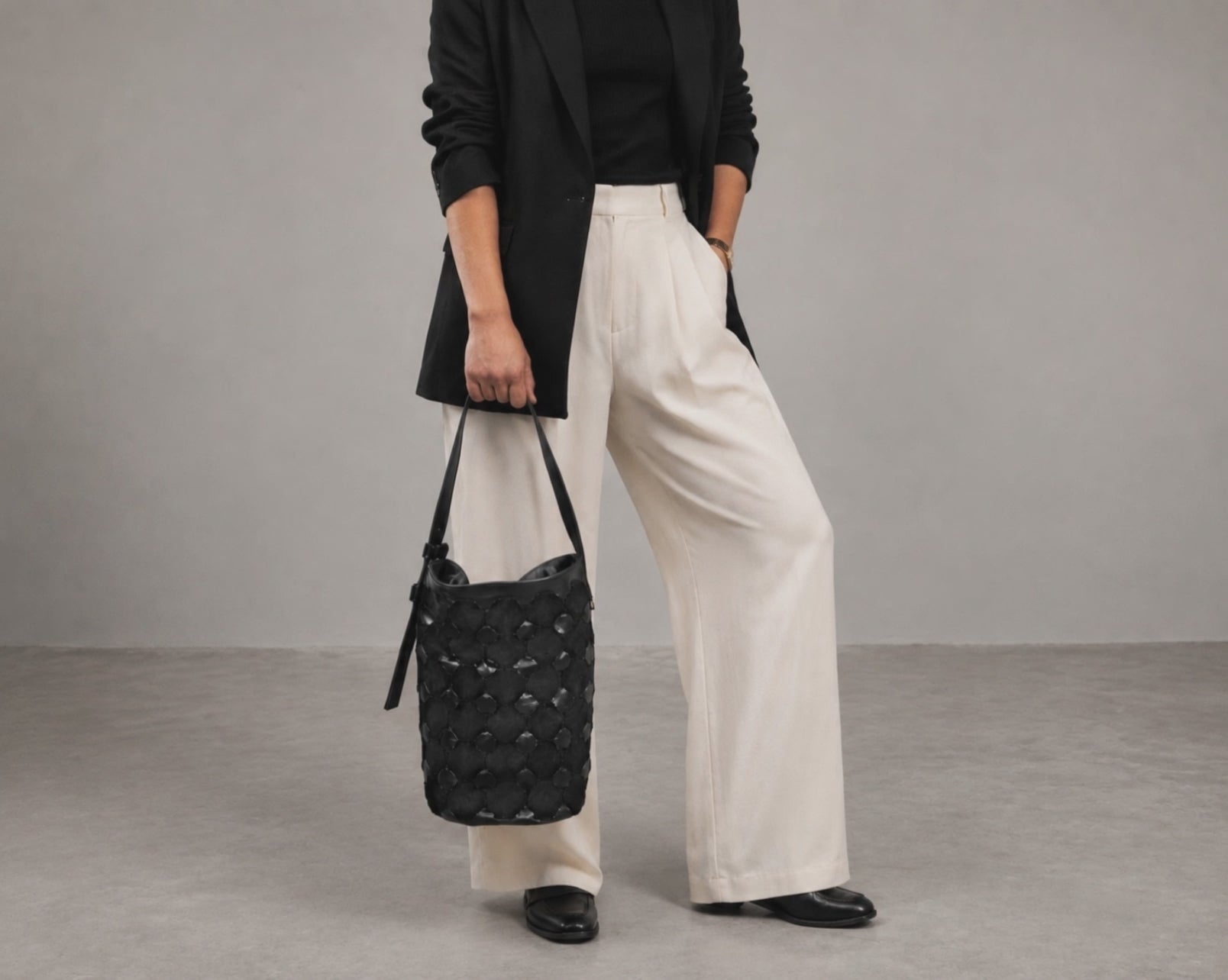 a woman carrying a black woven leather bag by milloo