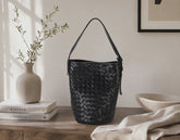 a black woven bag by milloo