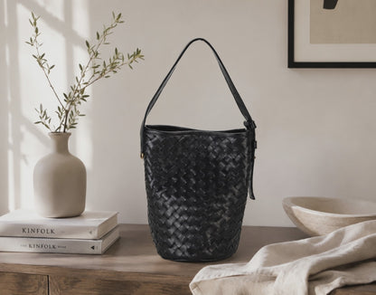 a black woven bag by milloo