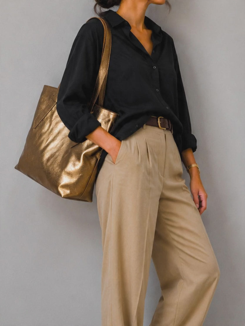 A woman carrying a metallic leather tote bag