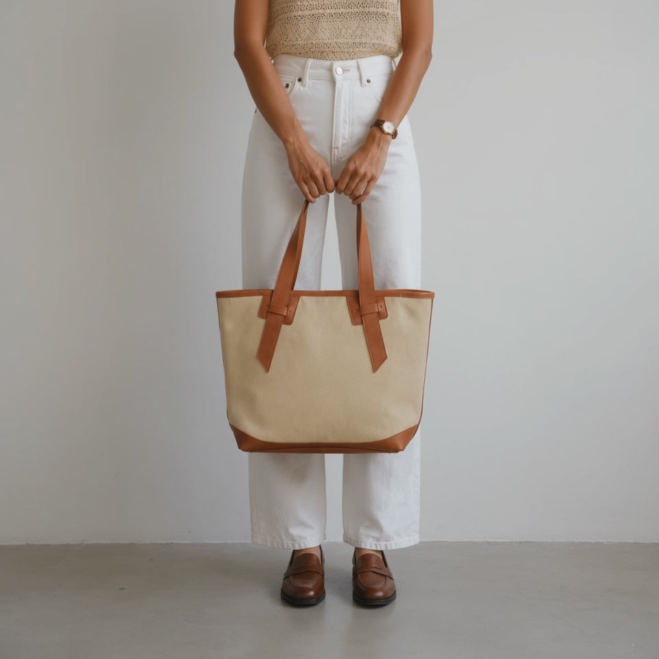 A woman carrying a cream tote bag