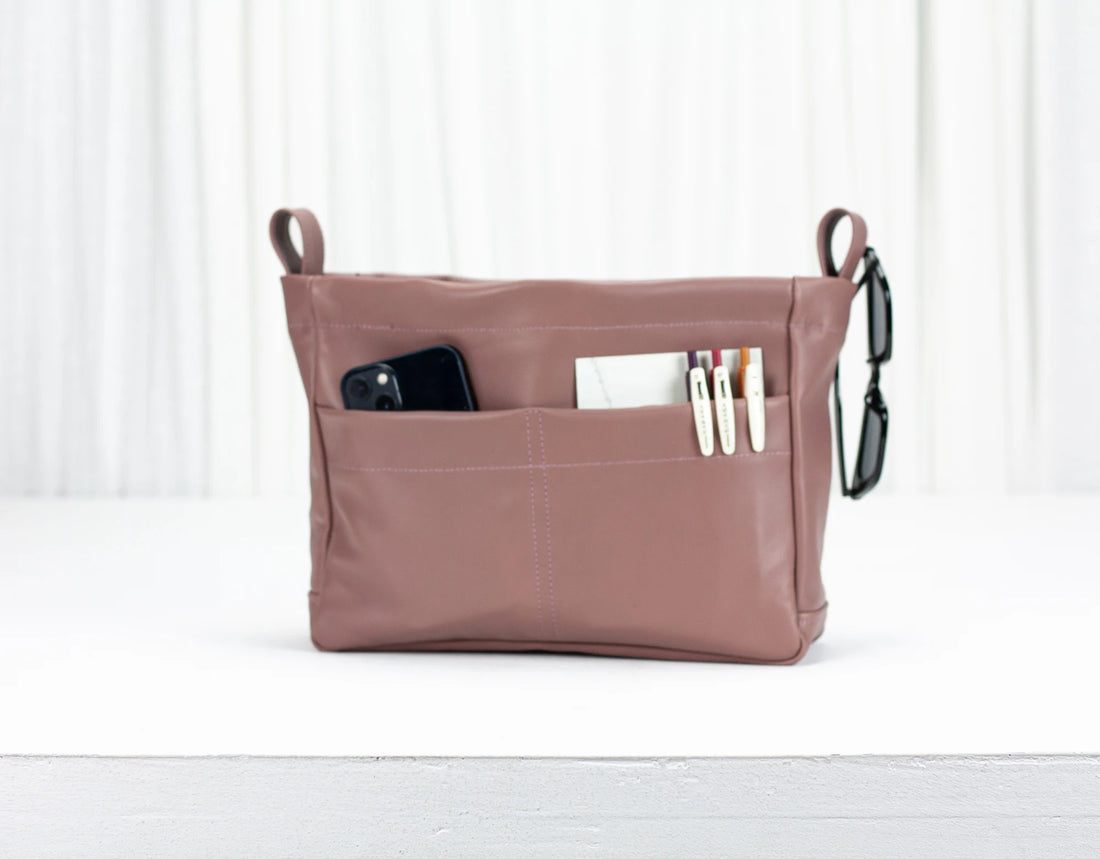Pink organizer bag with compartments on a white background
