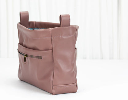 Pink leather bag with a gold zipper on a white background