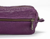 Purple leather bag with gold zipper on a white background