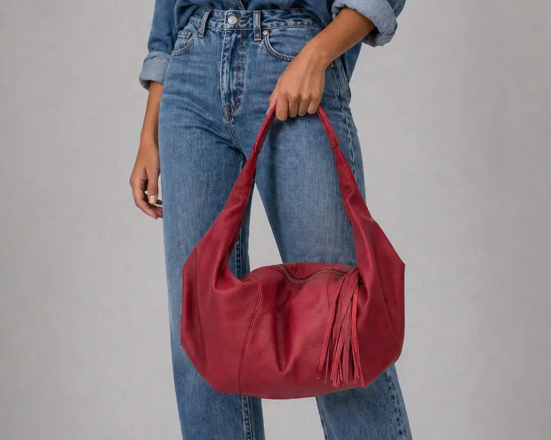Person wearing a denim outfit with a red handbag on a gray background