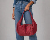 Person wearing a denim outfit with a red handbag on a gray background