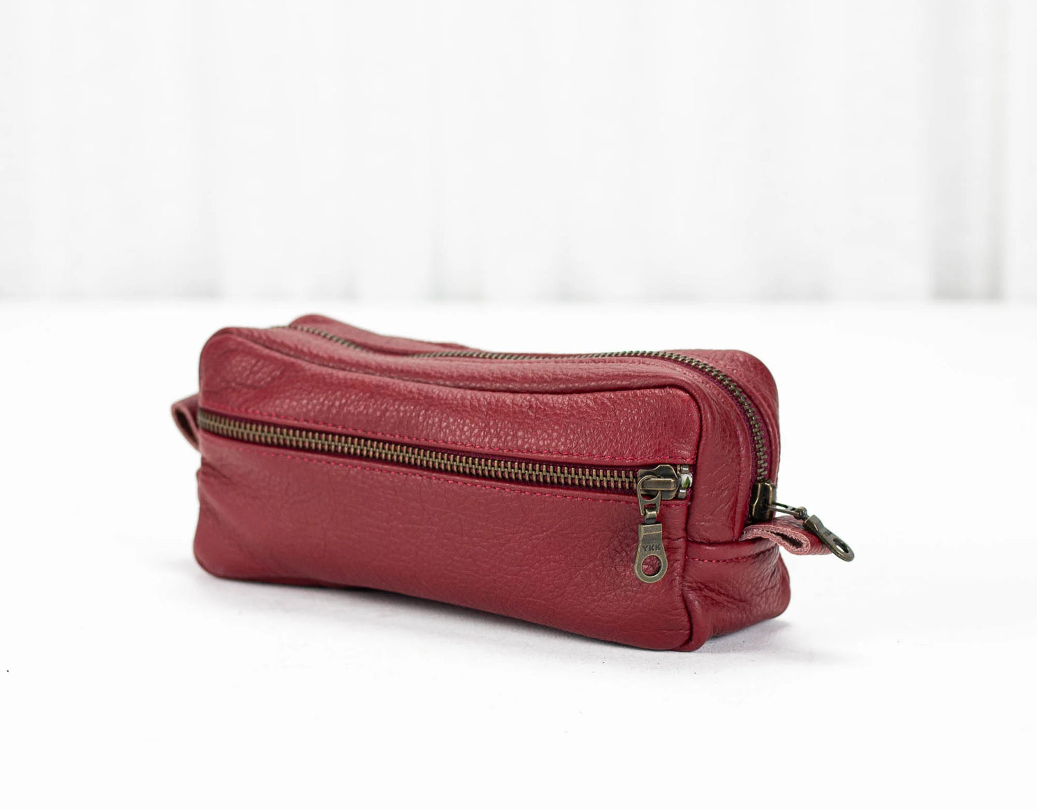 Red leather pouch with a zipper on a white background
