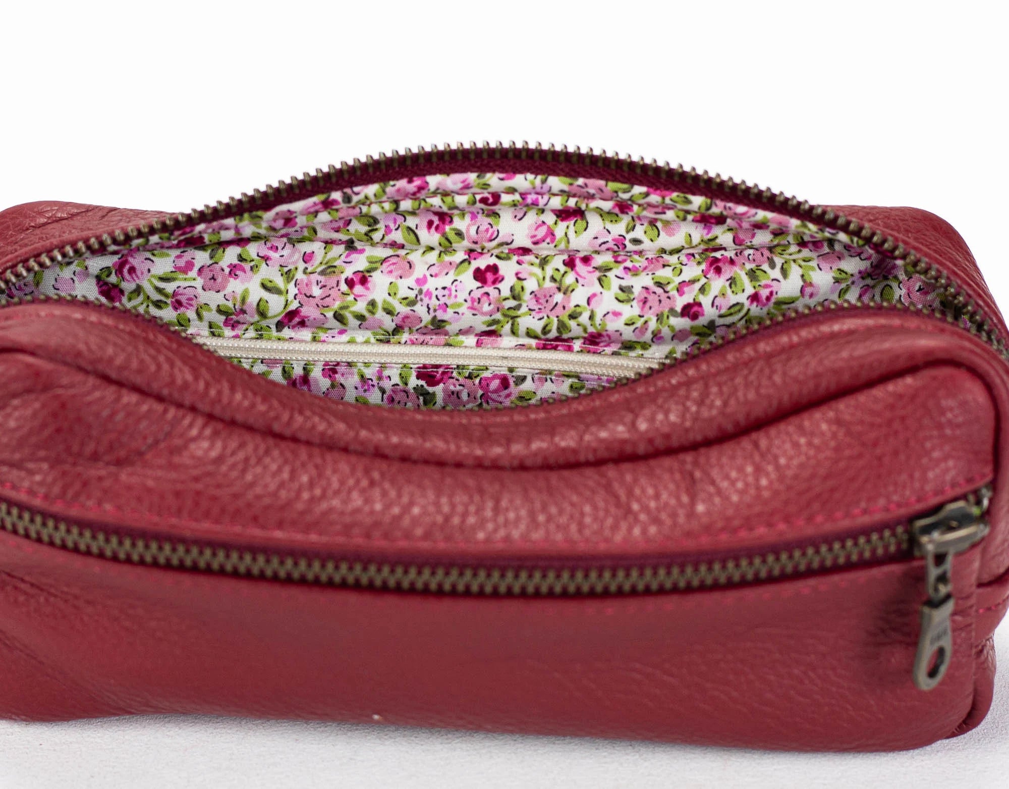Red leather pouch with floral interior on a white background