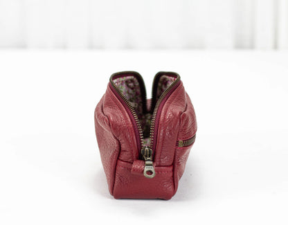 Red leather handbag with a zipper on a white background