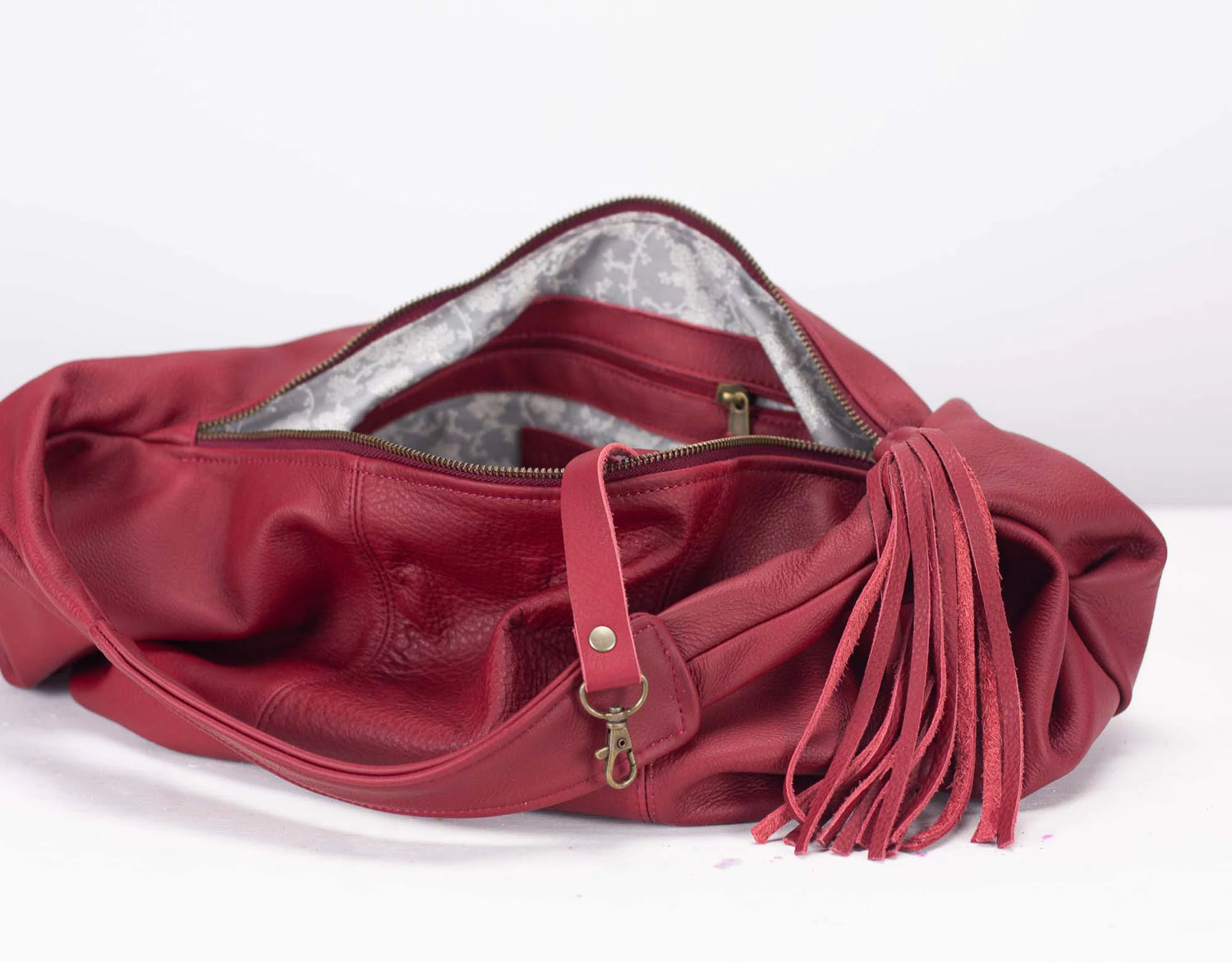 Red leather handbag with tassel on a white background