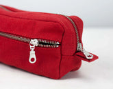 Red cotton pouch with silver zippers on a white background