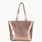 A metallic rose gold leather tote bag with two shoulder straps, shown against a plain off-white background.
