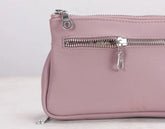 Pink leather bag with zippers on a light gray background