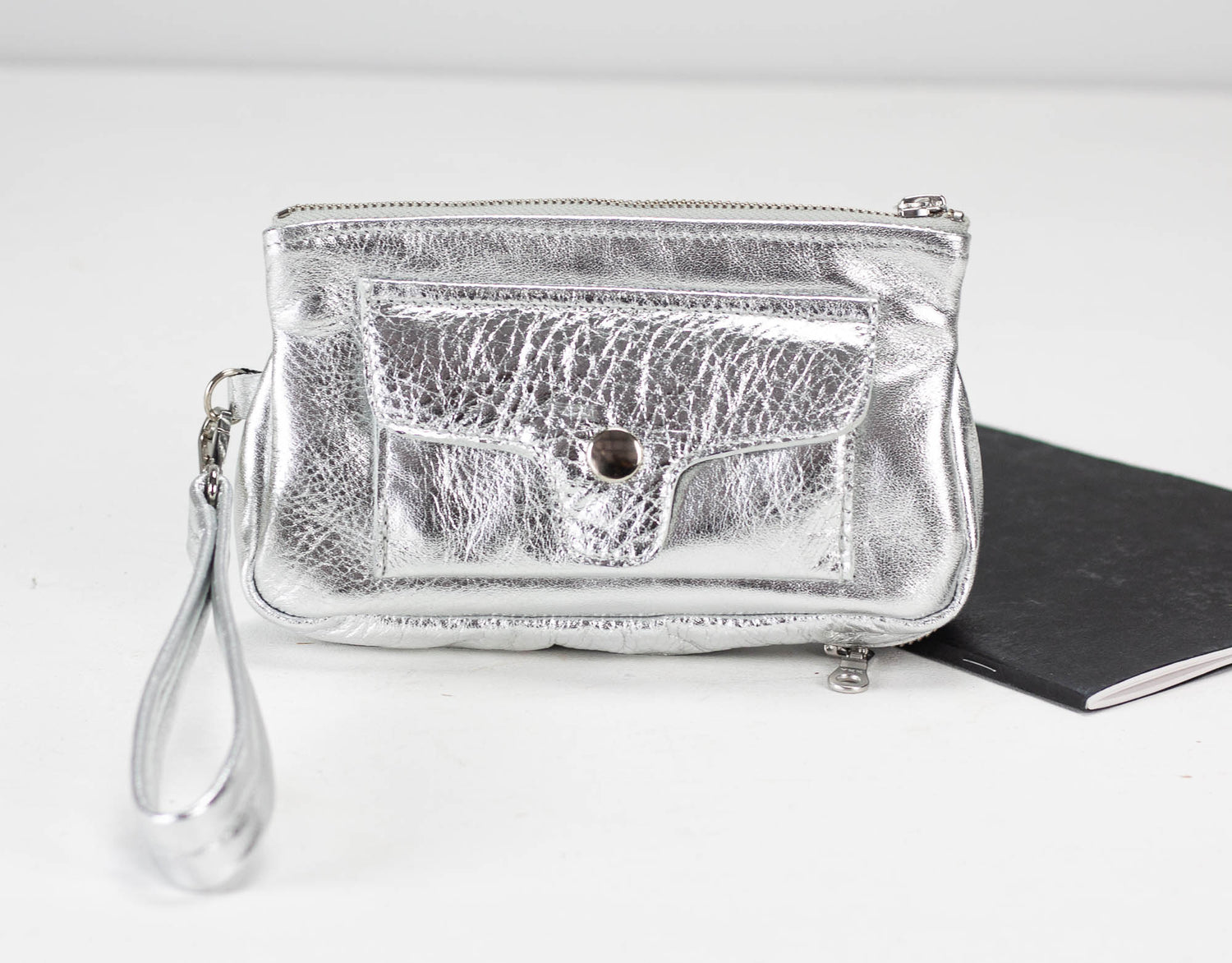 Silver clutch bag with a textured surface on a white background